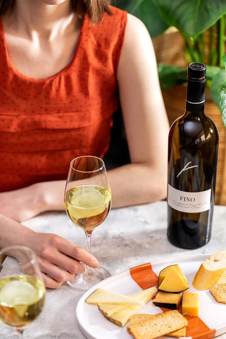 Vino blanco fino y plato con queso